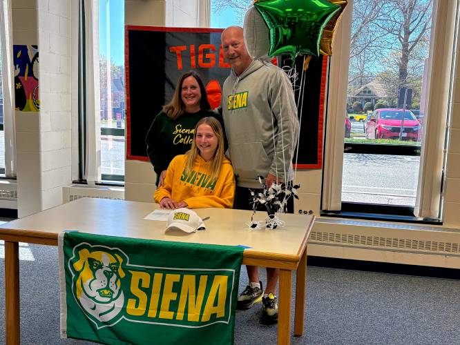 South Hadley’s Lauren Marjanski smiles with her parents Tracy and Rich after signing her National Letter of Intent to play soccer at Siena College on Monday in the library at South Hadley High School.