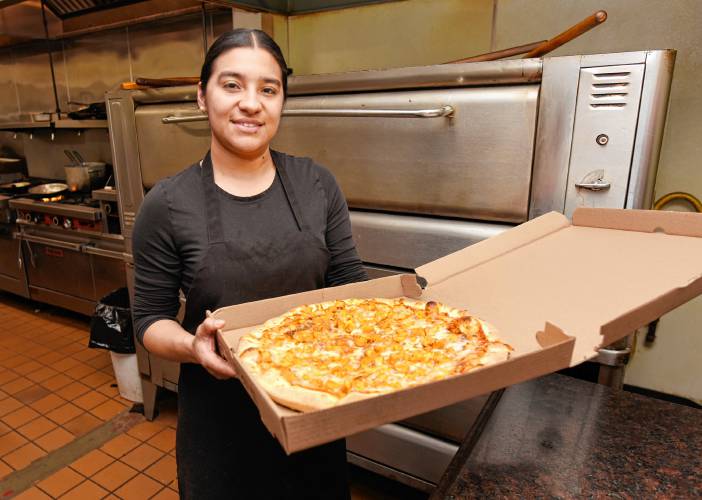 Claudia Rodas boxes up a pizza for delivery at Primo Restaurant & Pizzeria in South Deerfield. Rodas is part of a family group — including her husband and brother-in-law — who purchased the restaurant and have been running it since December. 