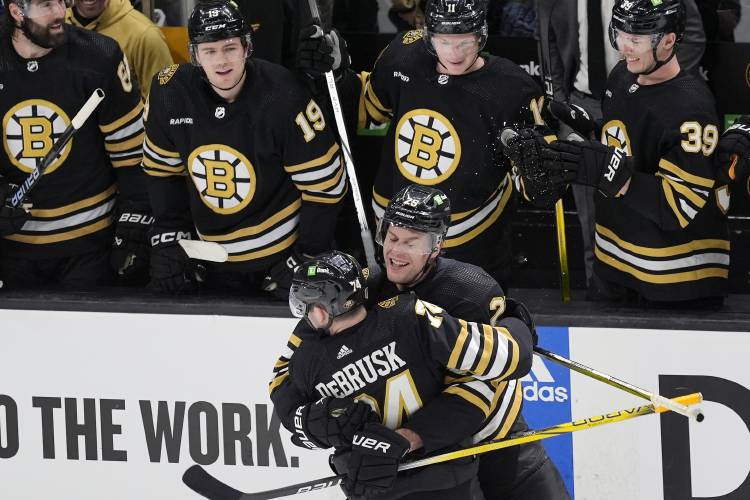 Boston Bruins' Brandon Carlo (25) celebrates his goal against the Toronto Maple Leafs with Jake DeBrusk (74) during the second period in Game 1 of an NHL hockey Stanley Cup first-round playoff series Saturday, April 20, 2024, in Boston. (AP Photo/Michael Dwyer)