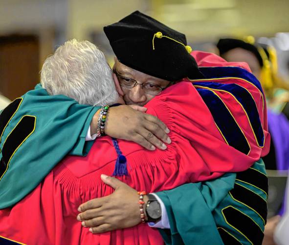 Timmons receives a hug from a colleague after his installation as the fifth president of Holyoke Community College.