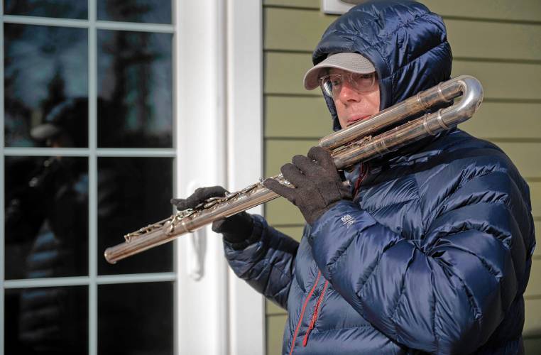 David Bond, a professional musician, plays his bass flute outside in the cold weather on Monday morning in Northampton’s Village Hill neighorhood. “It’s a morning meditation,” Bond explains of his daily routine. “It’s like exercising my lungs but by playing an instrument.”