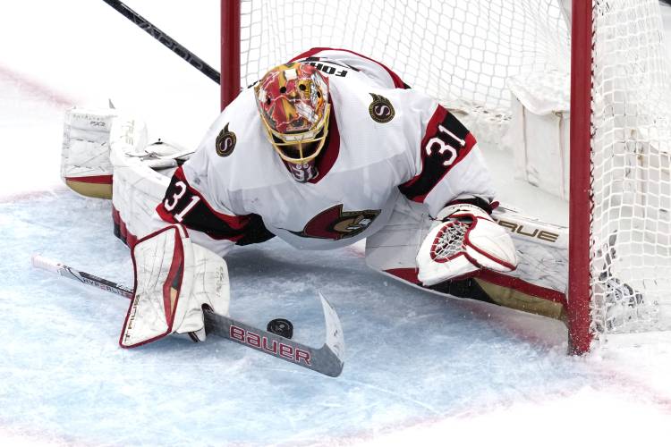 Ottawa Senators goaltender Anton Forsberg pounces on the puck while making a save against the Boston Bruins during the third period of an NHL hockey game Tuesday, April 16, 2024, in Boston. (AP Photo/Charles Krupa)