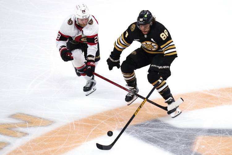 Ottawa Senators right wing Claude Giroux (28) tries to poke the puck away from Boston Bruins right wing David Pastrnak (88) during the second period of an NHL hockey game Tuesday, April 16, 2024, in Boston. (AP Photo/Charles Krupa)