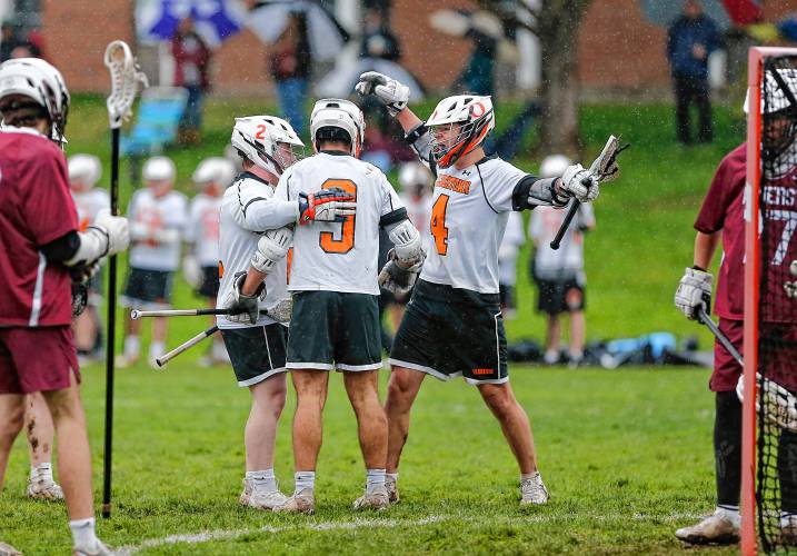 Belchertown’s Vinny Ting (4) celebrate with Caleb Reardon (2) after a goal by Nico St. George (9) in the second quarter against Amherst on Thursday in Belchertown.