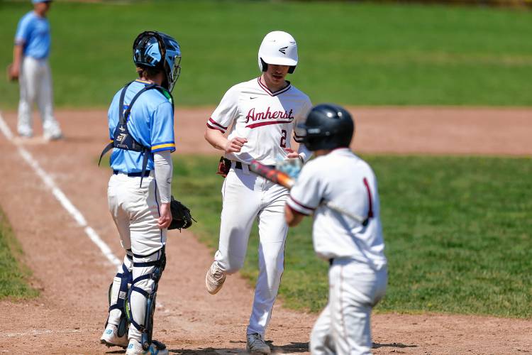Amherst baserunners Spencer Waite (1) and Thatcher Rudnik (2) score against Chicopee Comp in the bottom of the first inning Wednesday in Amherst.