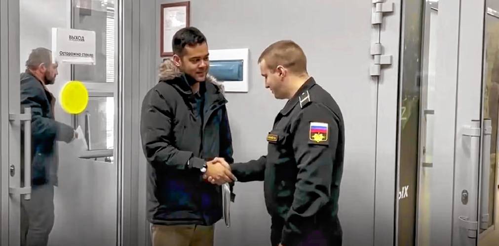Wilmer Puello-Mota is shown in a video still shaking hands with an official at a Russian army enlistment center in western Siberia. 