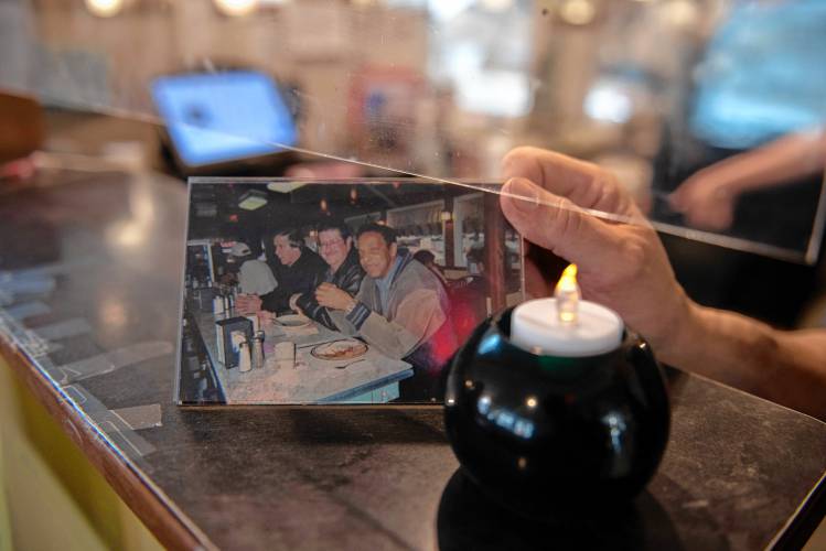 Jim Greco, the owner of Bluebonnet Diner, holds a photo of Bill Hairston, who ate at the diner most days. Hairston, at right in the photo, was a longtime counselor at the Veterans Administration in Leeds. He died March 22 at the age of 86.