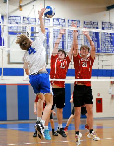 Granby’s Braeden Gallagher (4) attacks at the net over Athol’s Caunor Mason (13) and Jack Waslaske (21) in the second set Wednesday in Granby.