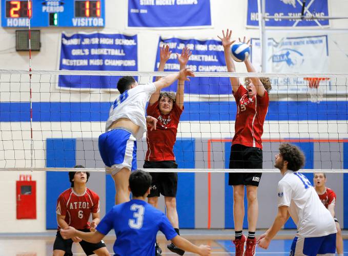 Granby’s Michael Swanigan (10) hits at the net over Athol’s Aiden Desruisseau (7) and Warren Taylor (9) in the first set Wednesday in Granby.