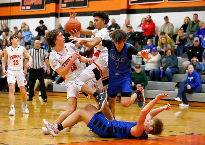 South Hadley’s Jack Loughrey (12) and Isiah James (11) fight for a loose ball against Granby’s Riley Goodhind (1) and Cody White (23) in the fourth quarter Wednesday night in South Hadley.