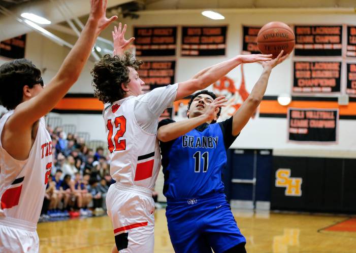 Granby’s Raymond D. Colon (11) drives to the hoop defended by South Hadley’s Jack Loughrey (12) in the second quarter Wednesday night in South Hadley.