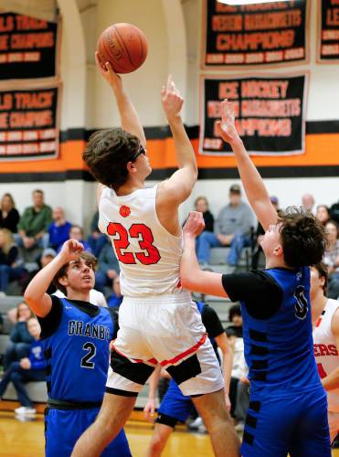 South Hadley’s Brady Currier (23) hooks a shot over Granby defenders Cody Breault (2) and Sawyer Clarke (0) in the third quarter Wednesday night in South Hadley.