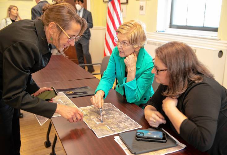 Carolyn Misch, left, who’s now director of the Department of Planning and Sustainability in Northampton; U.S. Sen. Elizabeth Warren; and Mayor Gina-Louise Sciarra look over a map of the Rocky Hill Greenway Multi-Use Trail at Northampton City Hall in April 2022.