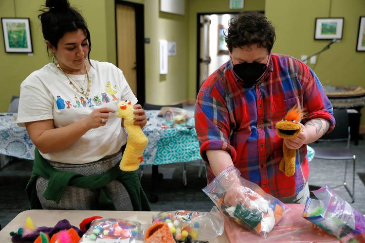 Samantha Morin, left, and Evan Delano work on their puppet creations during a deluxe sock puppet class by Homeslice Puppetry on Thursday night at the South Hadley Public Library. 