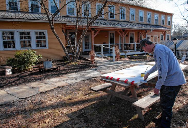 Darren Chevalier, a family member of the owners of the Old Mill in Hatfield, works on a repair at the inn on Monday afternoon.