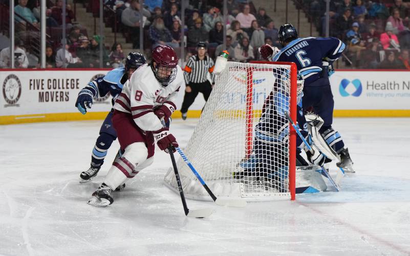 UMass forward Cam O’Neill (8) carries the puck behind the Maine net during the Minutemen’s 1-0 Hockey East loss on Saturday night at the Mullins Center in Amherst.