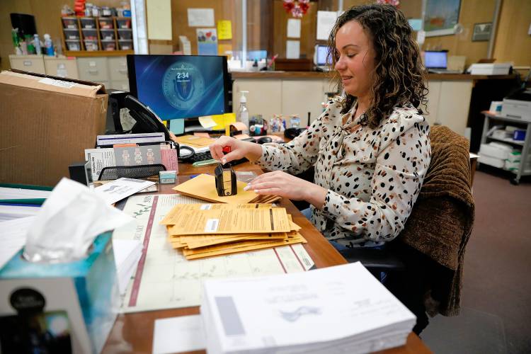 Principal clerk Jesenia Flores processes received mail-in ballots Friday afternoon at the Holyoke city clerk’s office.