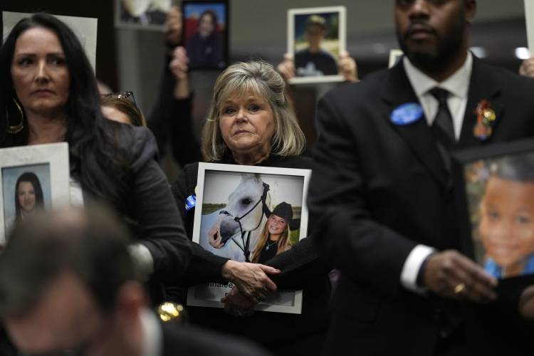 People hold photos of their loved ones as they sit in the audience before the start of a Senate Judiciary Committee hearing with the heads of social media platforms on Capitol Hill in Washington, Wednesday, Jan. 31, 2024, to discuss child safety. (AP Photo/Susan Walsh)